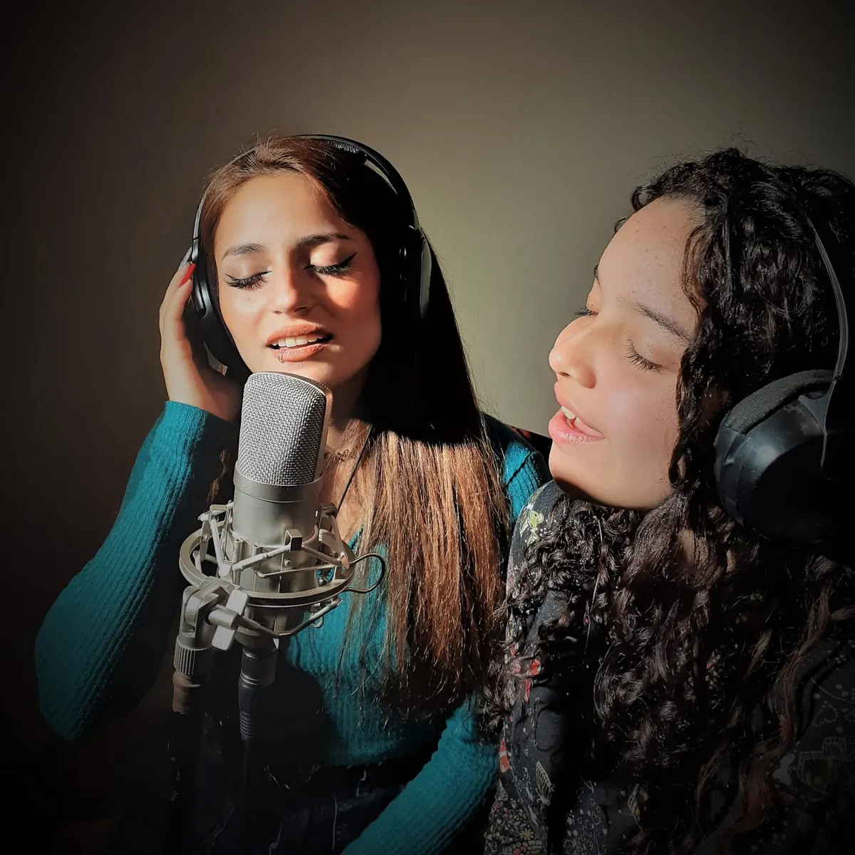 Alumnas cantando al micrófono con auriculares en sesión de grabación