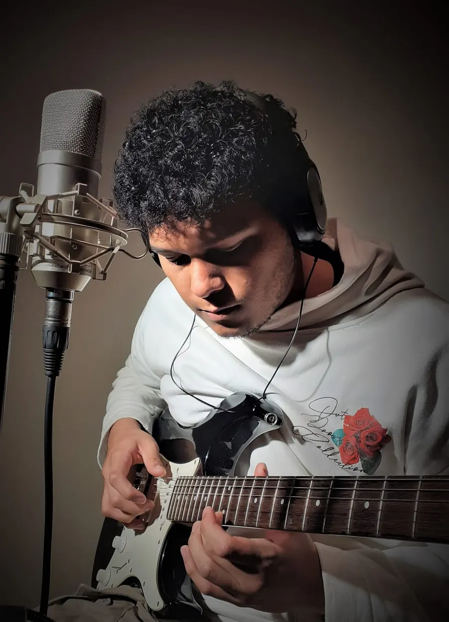 Alumno grabando con guitarra y micrófono